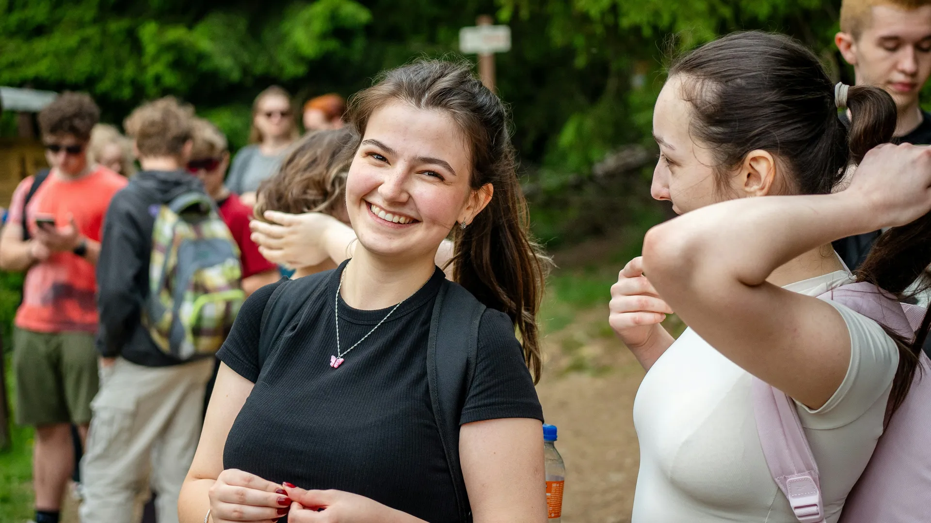 Uczniowie eksplorujący strumień w lesie podczas wycieczki szkolnej